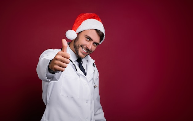 Young doctor in white uniform and Santa Claus hat