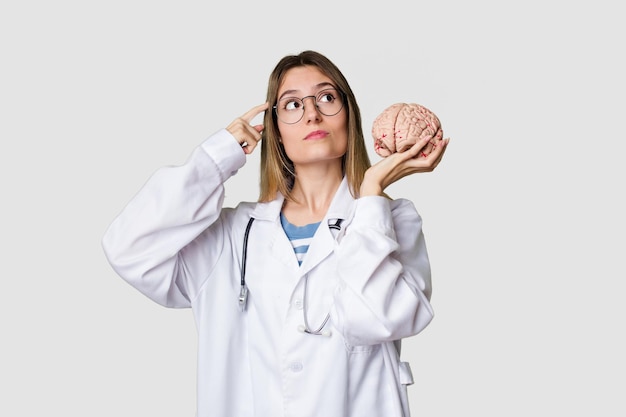 Young doctor woman holding a brain model