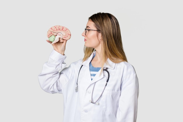 Young doctor woman holding a brain model