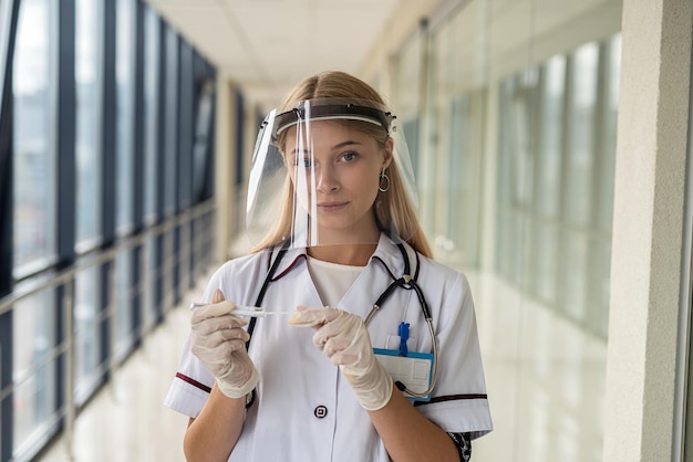 Young doctor woman in a white coat goes to take a test analysis on the covid