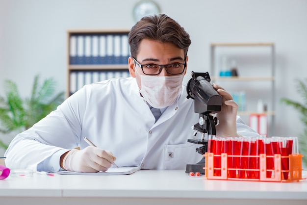 Young doctor working in the lab with microscope