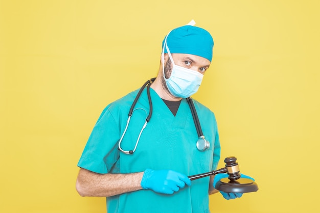 Young doctorsurgeon dressed in green on yellow background