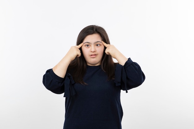 Young down syndrome girl in black sweater standing over white.