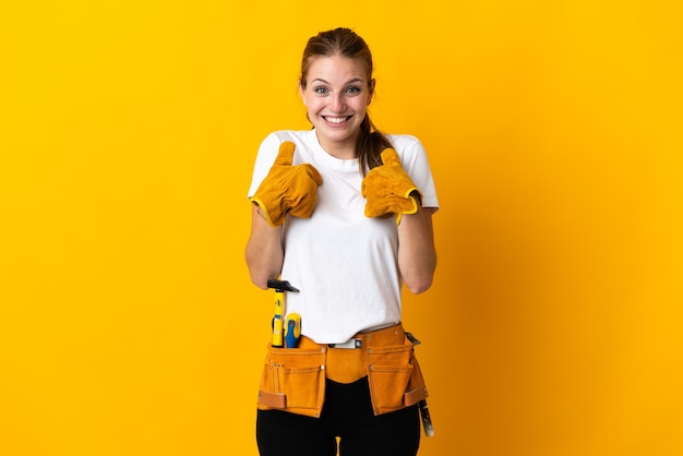 Young electrician woman isolated on yellow wall with surprise facial expression