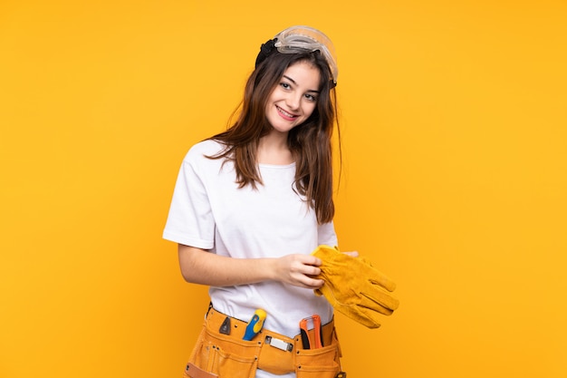 Young electrician woman over on yellow