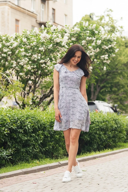 Young elegant brunette girl posing at city street Pretty beautiful business woman in elegant dress