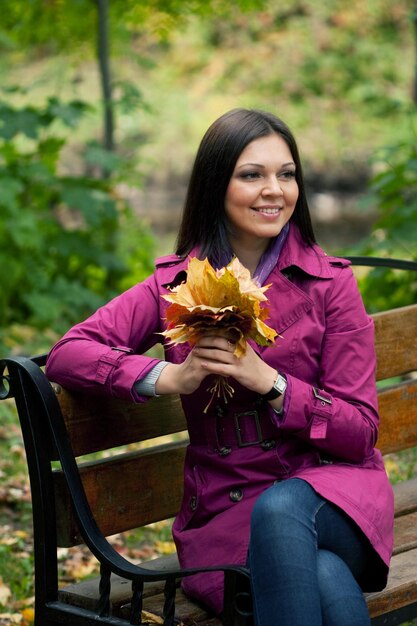 Young elegant woman with autumn leaves