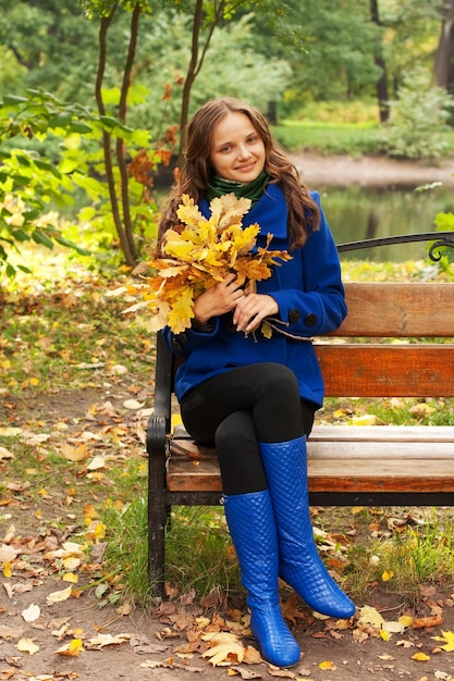 Young elegant woman with autumn leaves