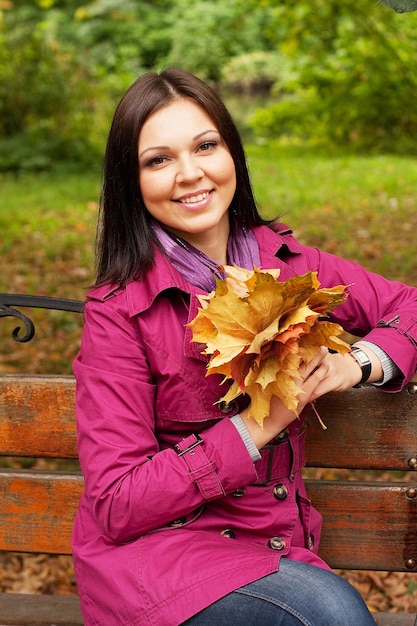 Young elegant woman with autumn leaves