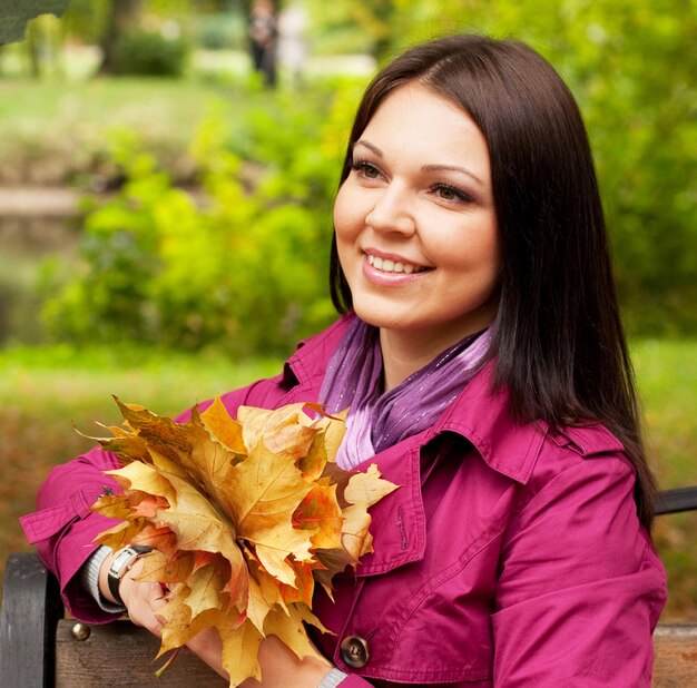 Young elegant woman with autumn leaves