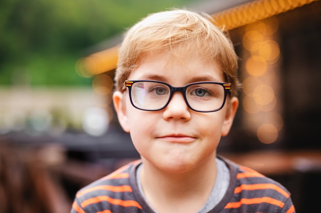 Young elementary boy with blonde hair and glasses