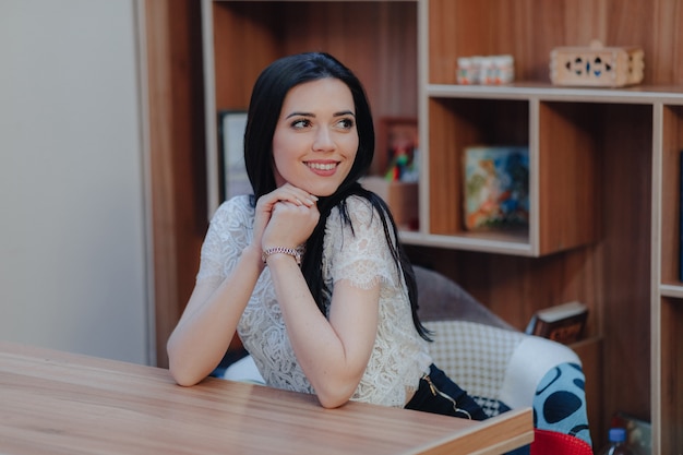 Photo young emotional attractive girl sitting at a desk in a modern office or auditorium