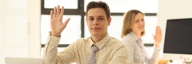 Young employees in the office raised their hands closeup approval and voting teamwork business