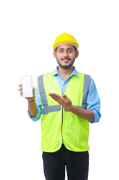 Young engineer showing smartphone screen on white background.