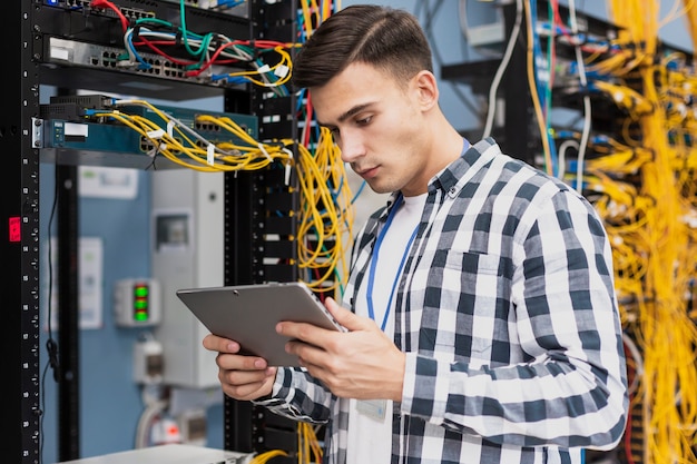 Young engineer with a tablet in server room medium shot