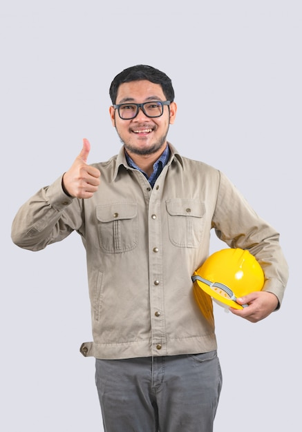 Young engineer with yellow hard hat and thumbs up