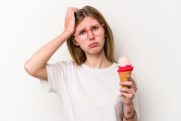 Young English woman holding an ice cream isolated on white background being shocked she has remembered important meeting