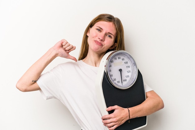 Young English woman holding a scale isolated on white background feels proud and self confident example to follow