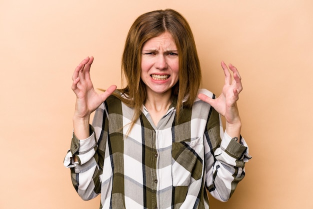 Photo young english woman isolated on beige background screaming with rage.