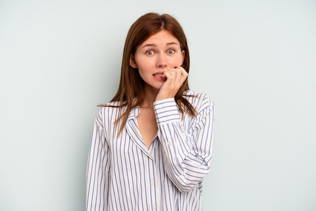 Young English woman isolated on blue background biting fingernails nervous and very anxious