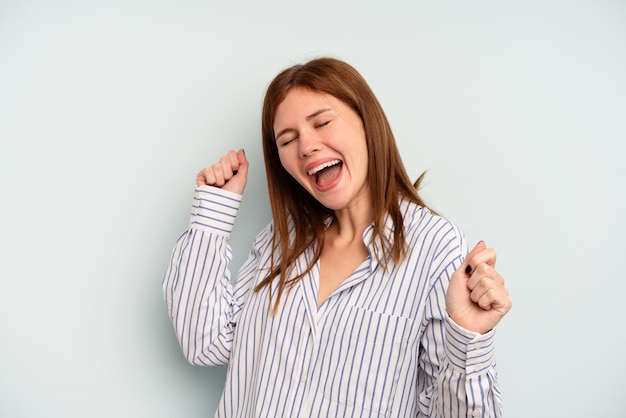 Young English woman isolated on blue background dancing and having fun.