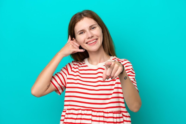 Photo young english woman isolated on blue background making phone gesture and pointing front