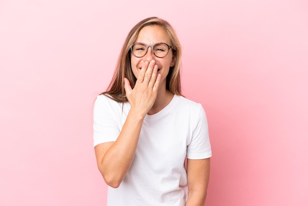 Young English woman isolated on pink background happy and smiling covering mouth with hand