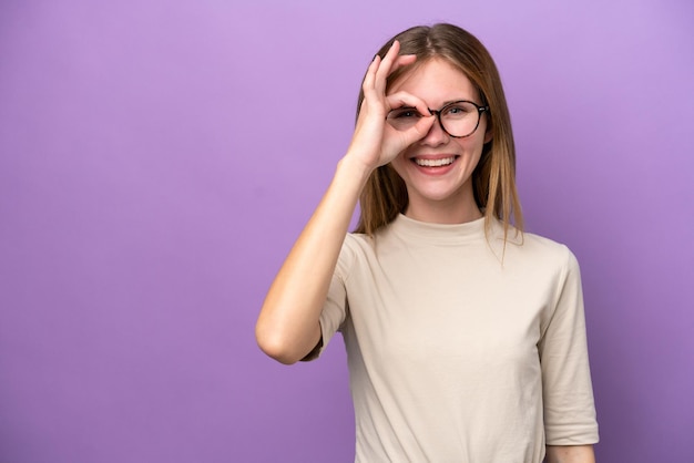 Young English woman isolated on purple background showing ok sign with fingers