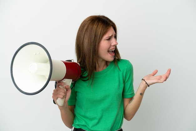 Young English woman isolated on white background holding a megaphone and with surprise facial expression