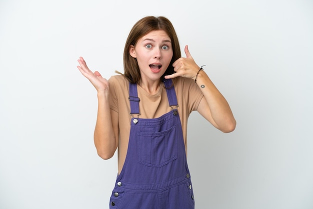 Young English woman isolated on white background making phone gesture and doubting