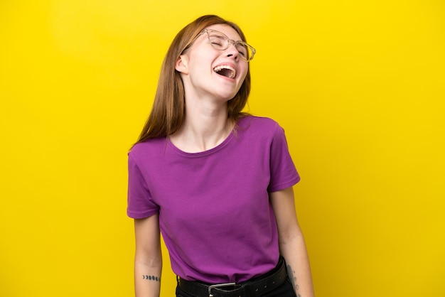 Young English woman isolated on yellow background laughing