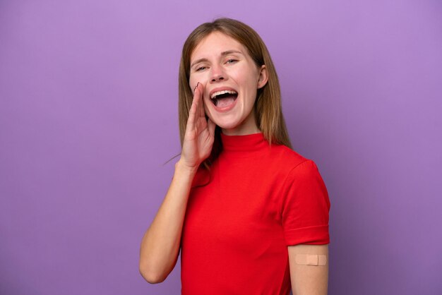 Young English woman wearing bandaids isolated on purple background shouting with mouth wide open