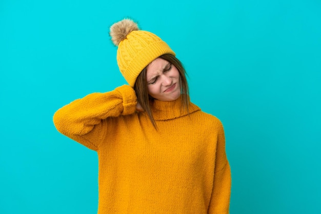 Young English woman wearing winter jacket isolated on blue background with neckache