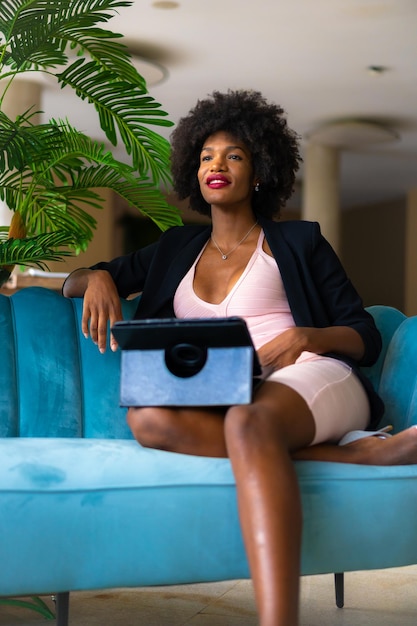 Young entrepreneur of black race and afro hair making a video call of a work meeting