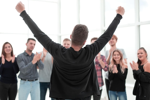 Young entrepreneur standing in front of the applauding business team