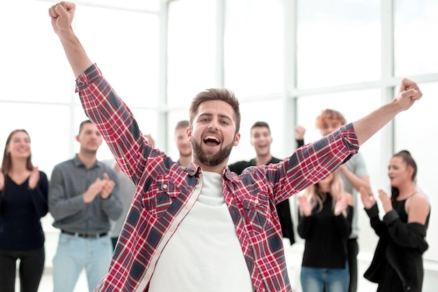 Young entrepreneur standing in front of the applauding business team