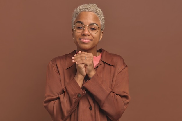 Young ethnic african american woman hands folded asks for help stands in studio