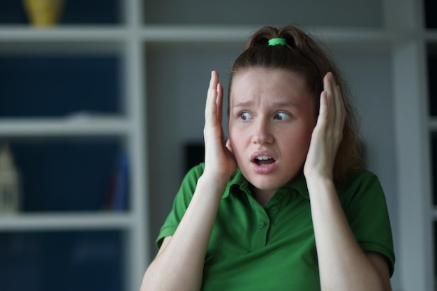 Young european woman sitting on the sofa at home afraid and shocked with surprise expression fear