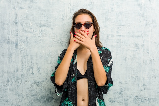 Young european woman wearing bikini shocked covering mouth with hands.