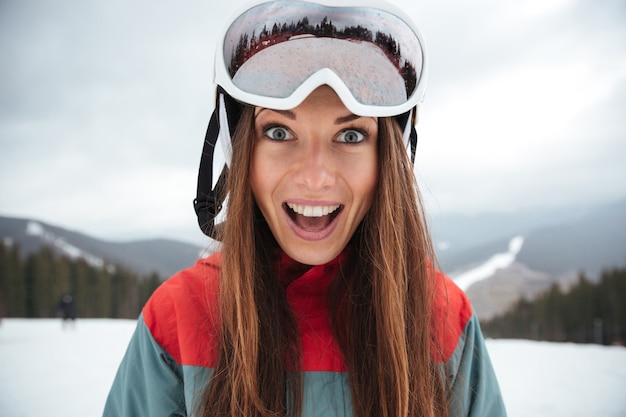 Young excited happy lady snowboarder on the slopes frosty winter day