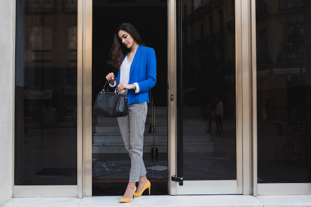 Young executive looking for something in her handbag