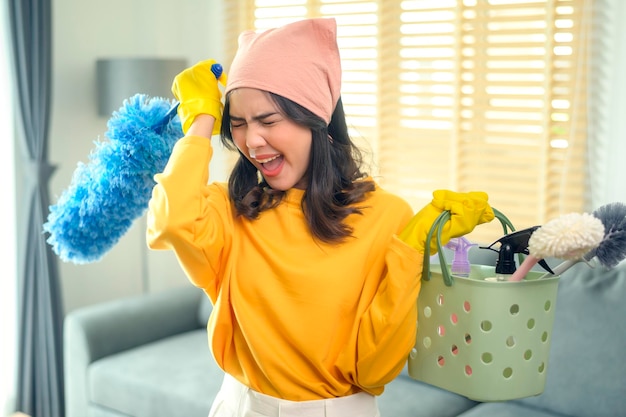 Young exhausted and tired housekeeper wearing yellow shirt in living room