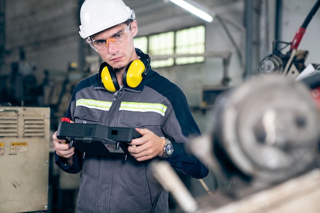 Young factory worker working with adept robotic arm