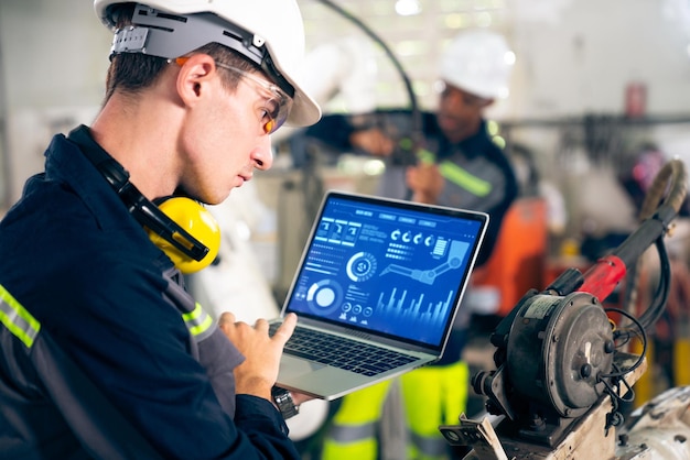 Young factory worker working with adept robotic arm