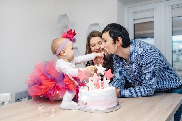 Young family celebrating birthday with a cake