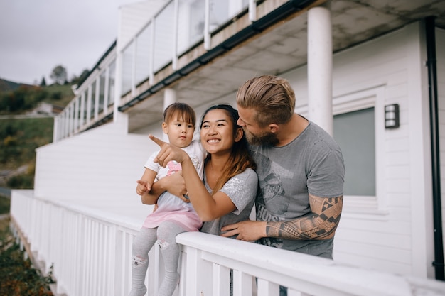 Young family and child looking into the distance on the home terrace