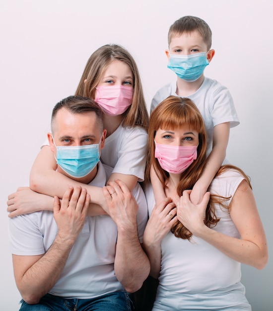 Young family in medical masks during home quarantine.