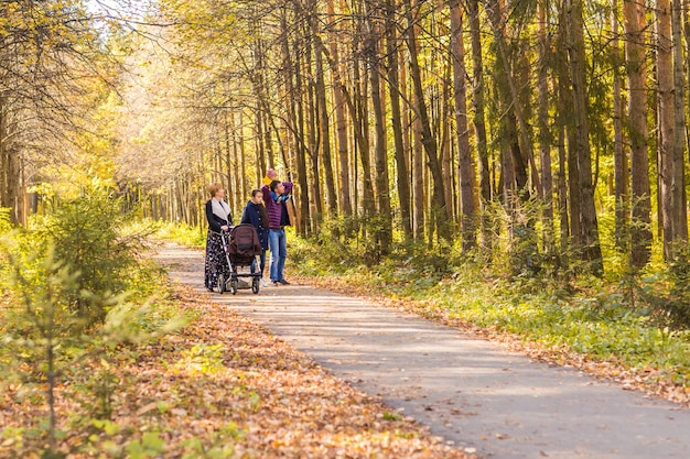 Young Family Outdoors Walking Through Autumn Park