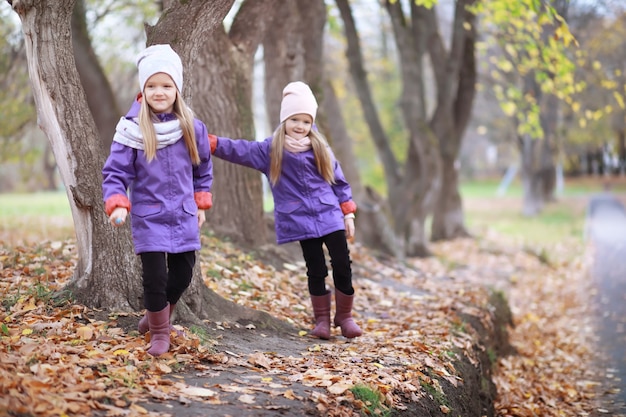 Young family on a walk in the autumn park on a sunny day. Happiness to be together.