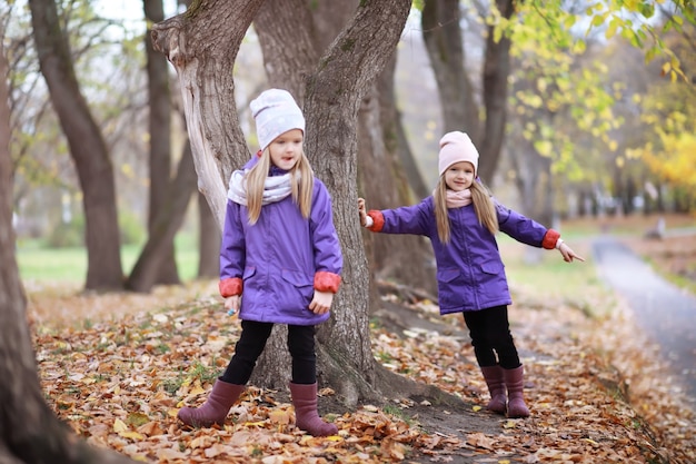 Young family on a walk in the autumn park on a sunny day. Happiness to be together.